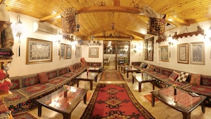 A traditional interior with wooden beams, patterned sofas, and a central rug. - Venus Hotel (Denizli)