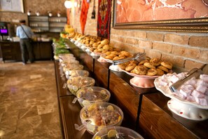 A buffet with various food items and a man in the background. - Venus Hotel (Denizli)