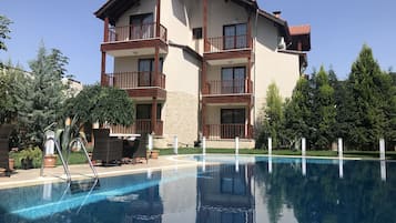 Una piscina al aire libre, sillones reclinables de piscina