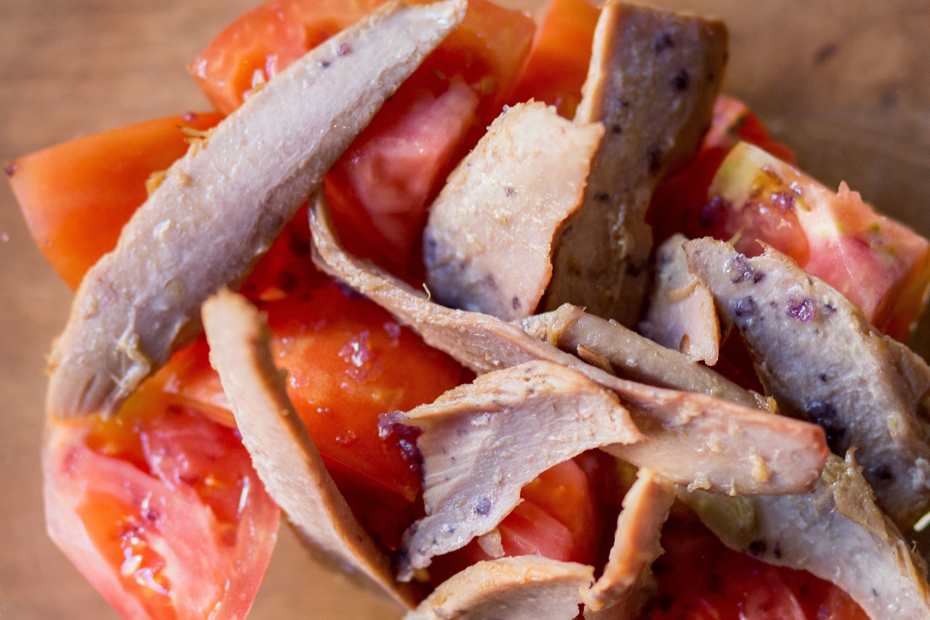 Gros plan sur de la viande et des tomates coupées en tranches.