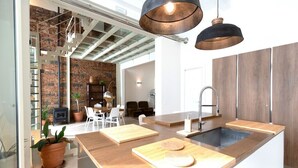 Una cocina moderna con una isla central, encimeras de madera e iluminación colgante.