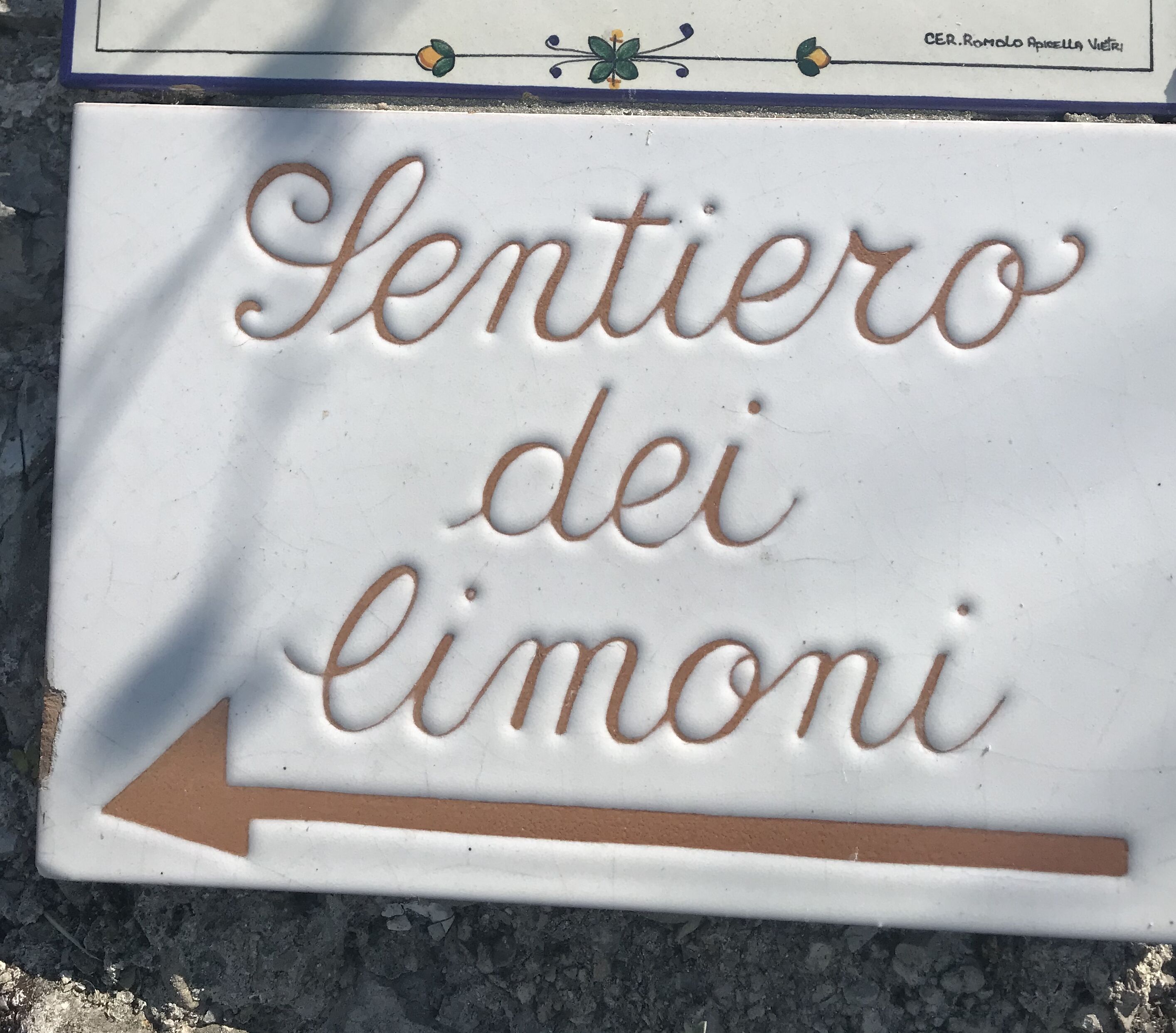 A sign with the text "Sentiero dei limoni" and an arrow pointing to the right.