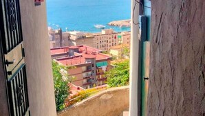 A narrow stairway leading to a balcony with a view of the sea and buildings. - Palazzo Cocò (Maiori)