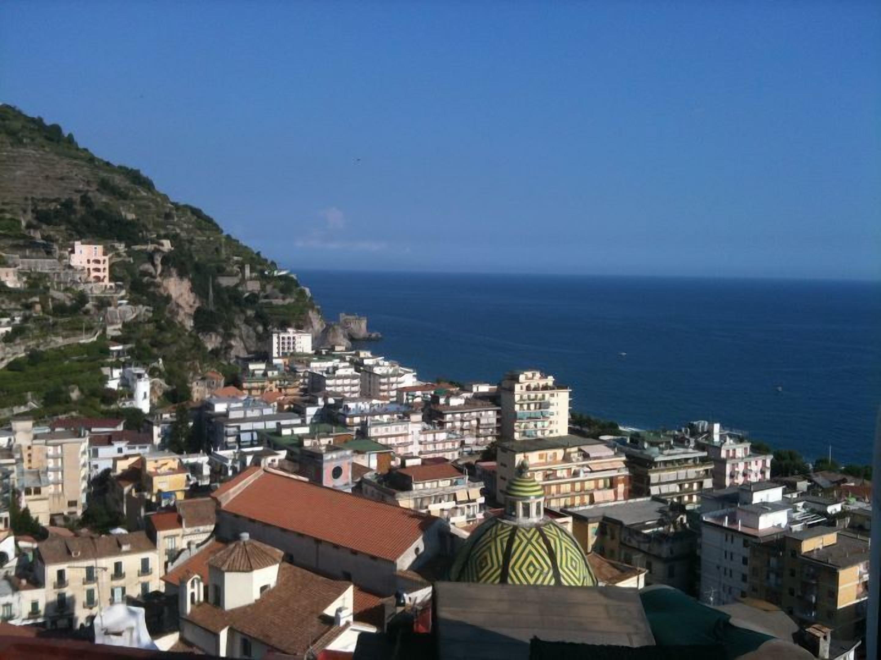 A coastal town with buildings along the hillside and a view of the sea.