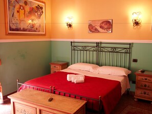 Une chambre comprenant un lit, une table de chevet, une commode et des luminaires fixés au mur.