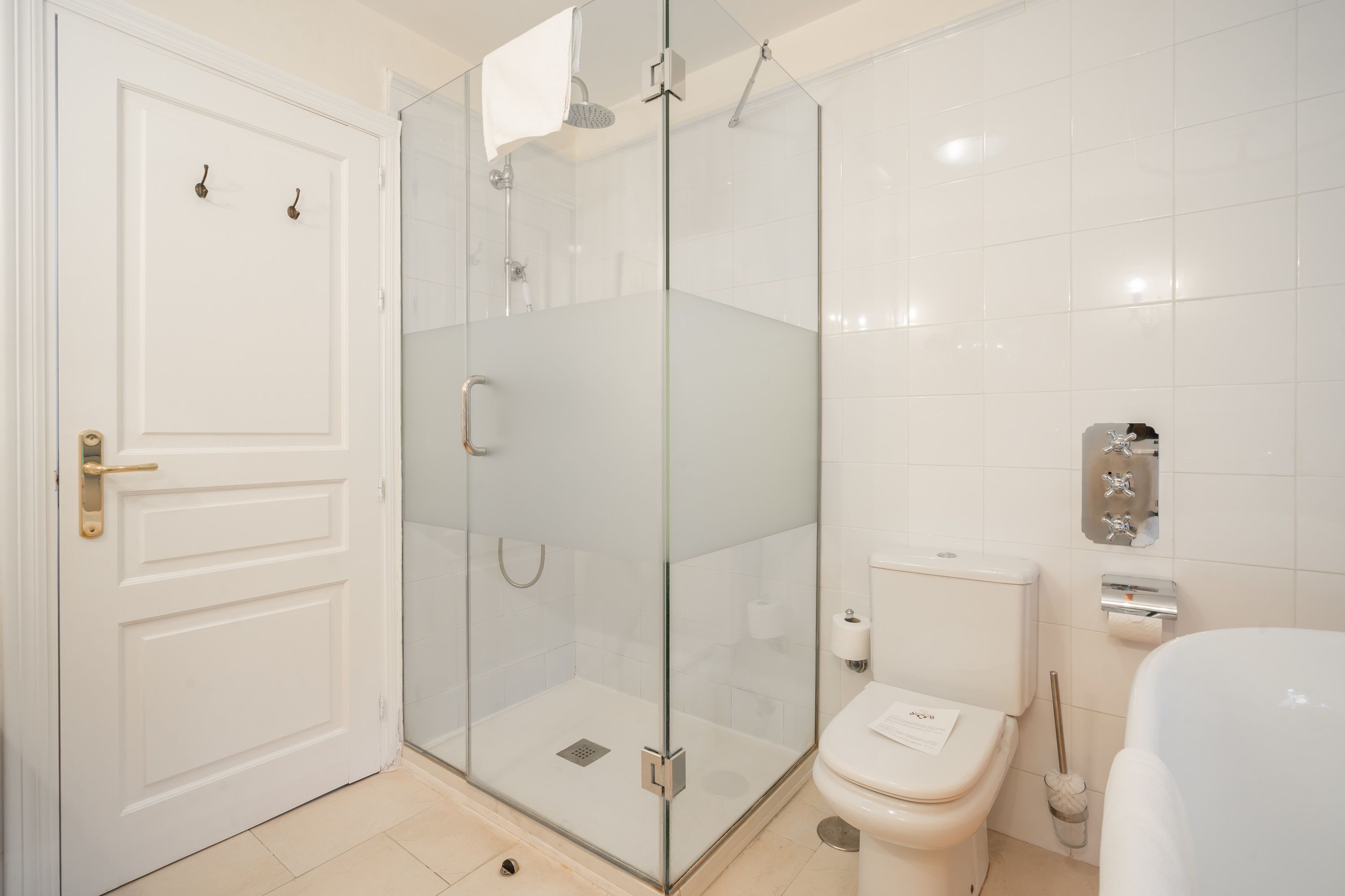 A modern bathroom with a glass-enclosed shower, a toilet, and a sink.