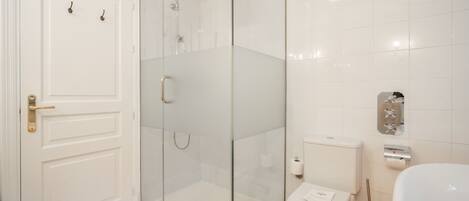 A modern bathroom with a glass-enclosed shower, a toilet, and a sink.
