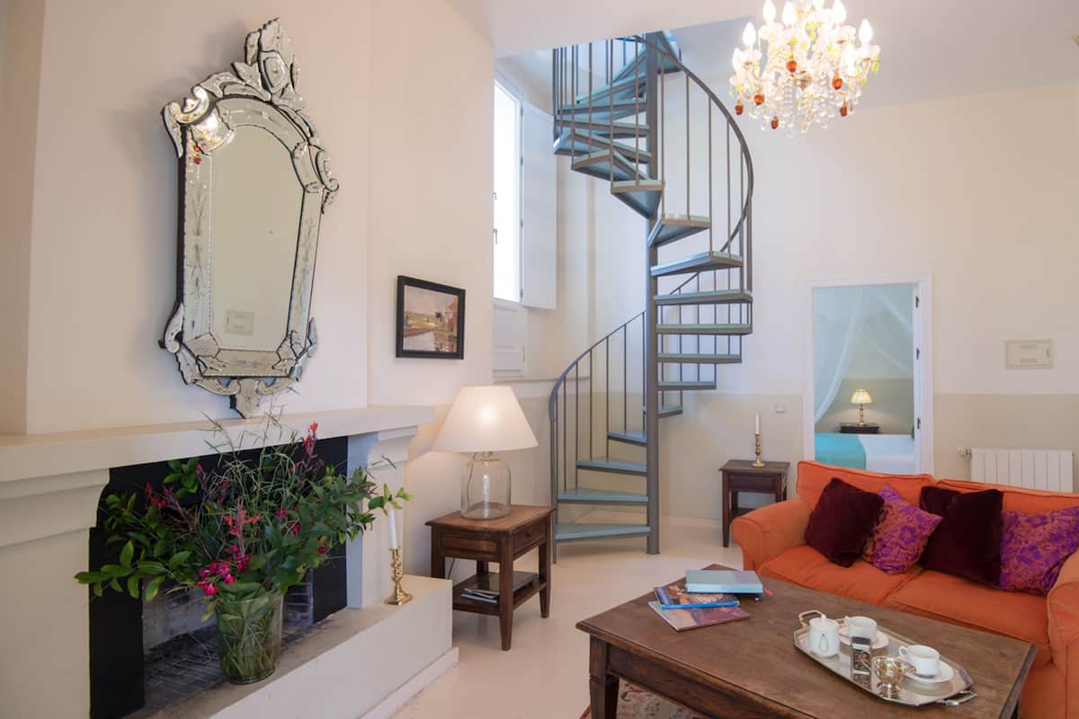 Un salon avec une cheminée, un escalier, un canapé et une table basse.