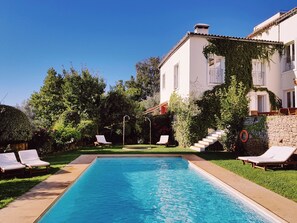 Una piscina al aire libre, tumbonas