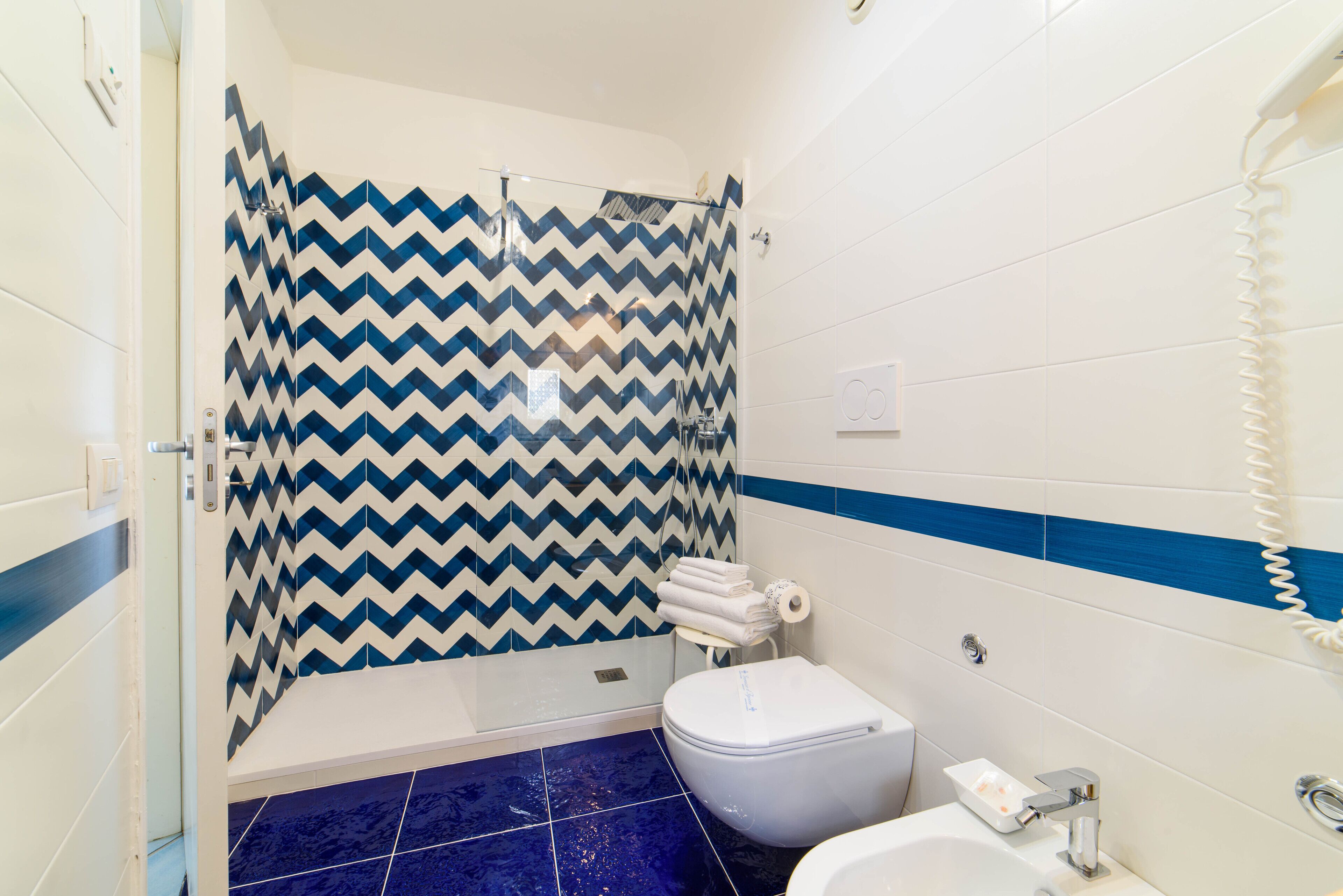Une salle de bain avec douche, toilettes et lavabo.