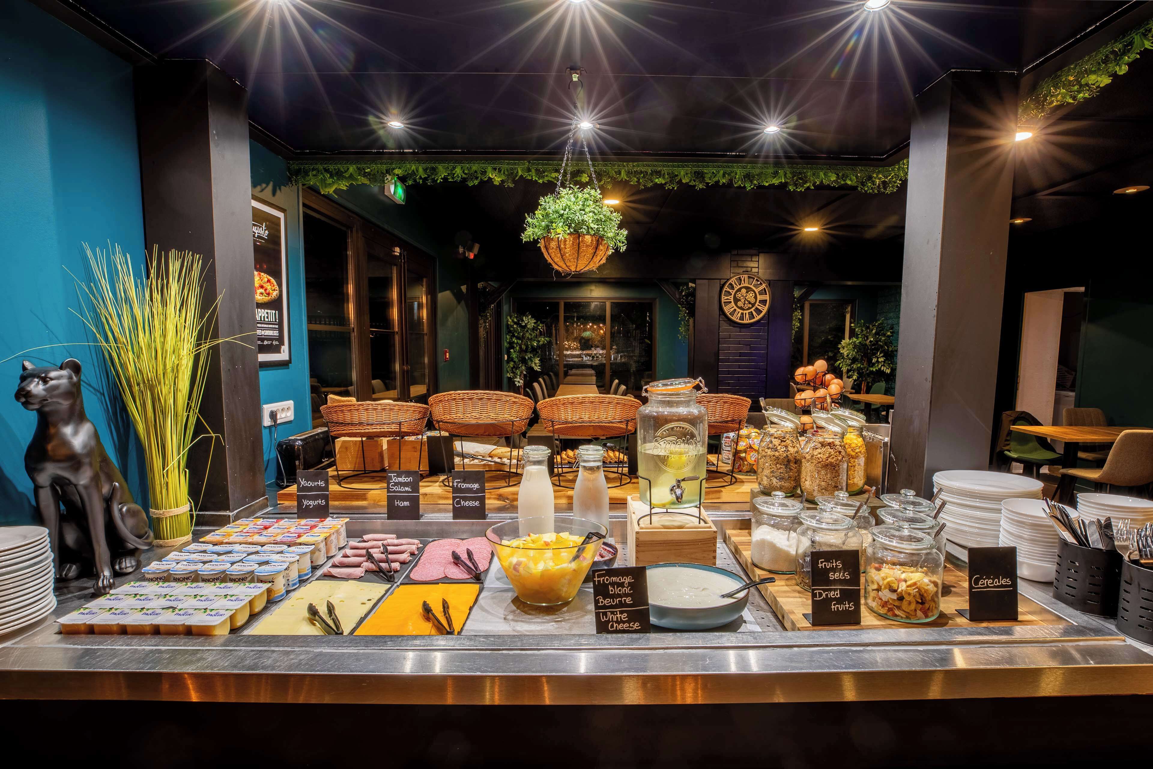 A breakfast buffet with various food items and a decorative statue.