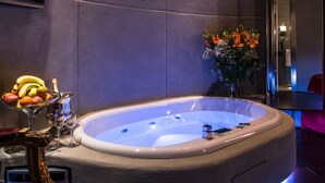 Un baño moderno con una bañera grande, un espejo y un florero con flores.