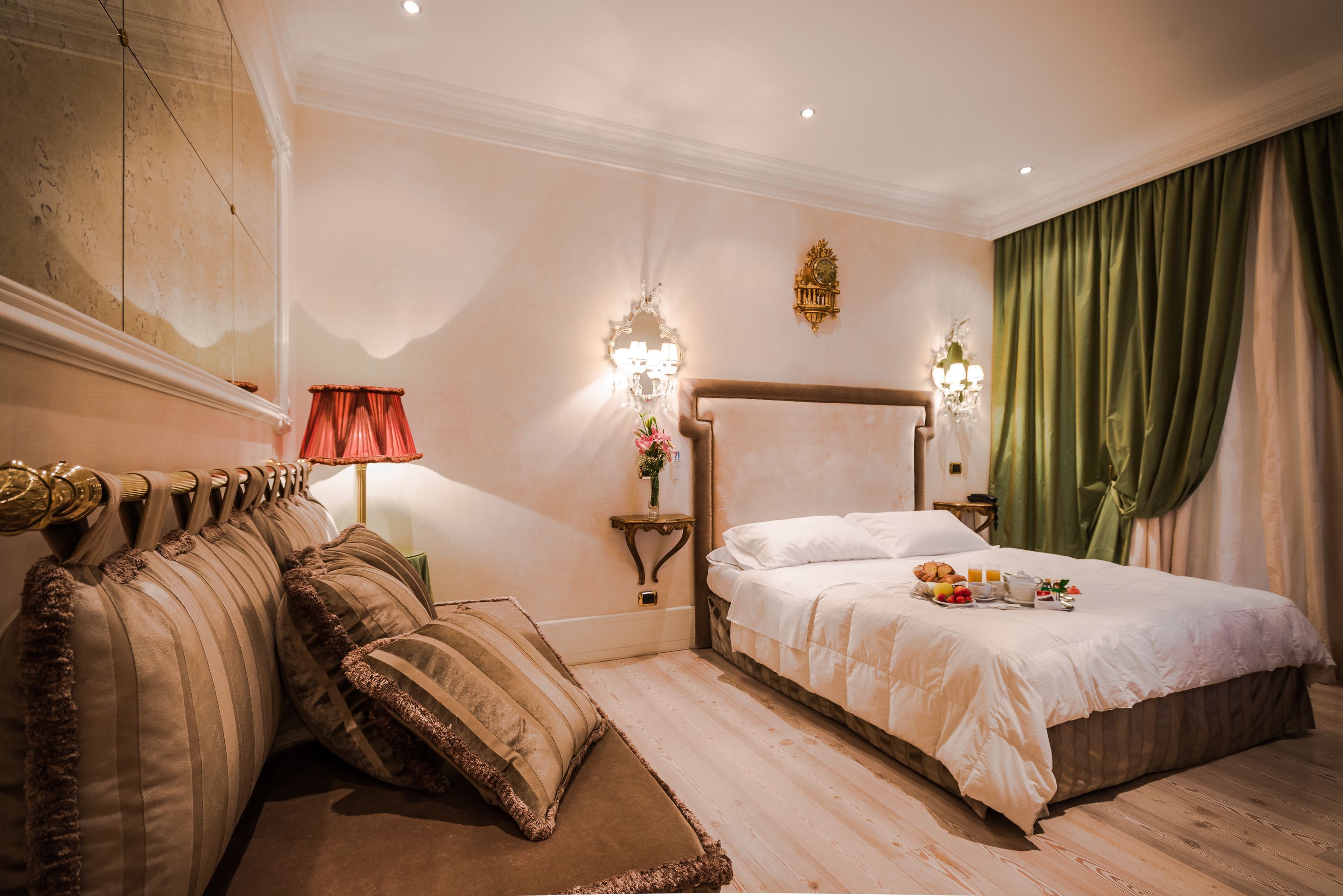 Une chambre avec un grand lit, un canapé, une table de chevet avec une lampe et un luminaire fixé au mur.