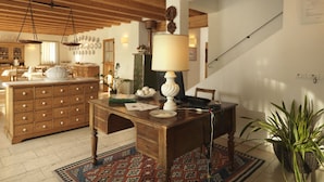 A traditional kitchen with wooden cabinets, a dining table, and a staircase leading to an upper level. - Villa Toderini Agriturismo (Codogne)