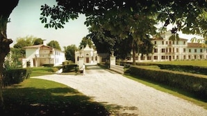 A large, historic building with a formal entrance, manicured gardens, and a gravel driveway. - Villa Toderini Agriturismo (Codogne)