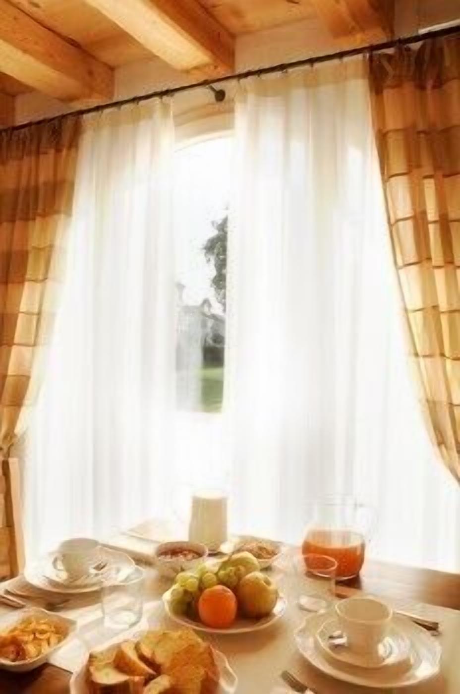 A breakfast table with plates of food, a glass of orange juice, and a cup of coffee.