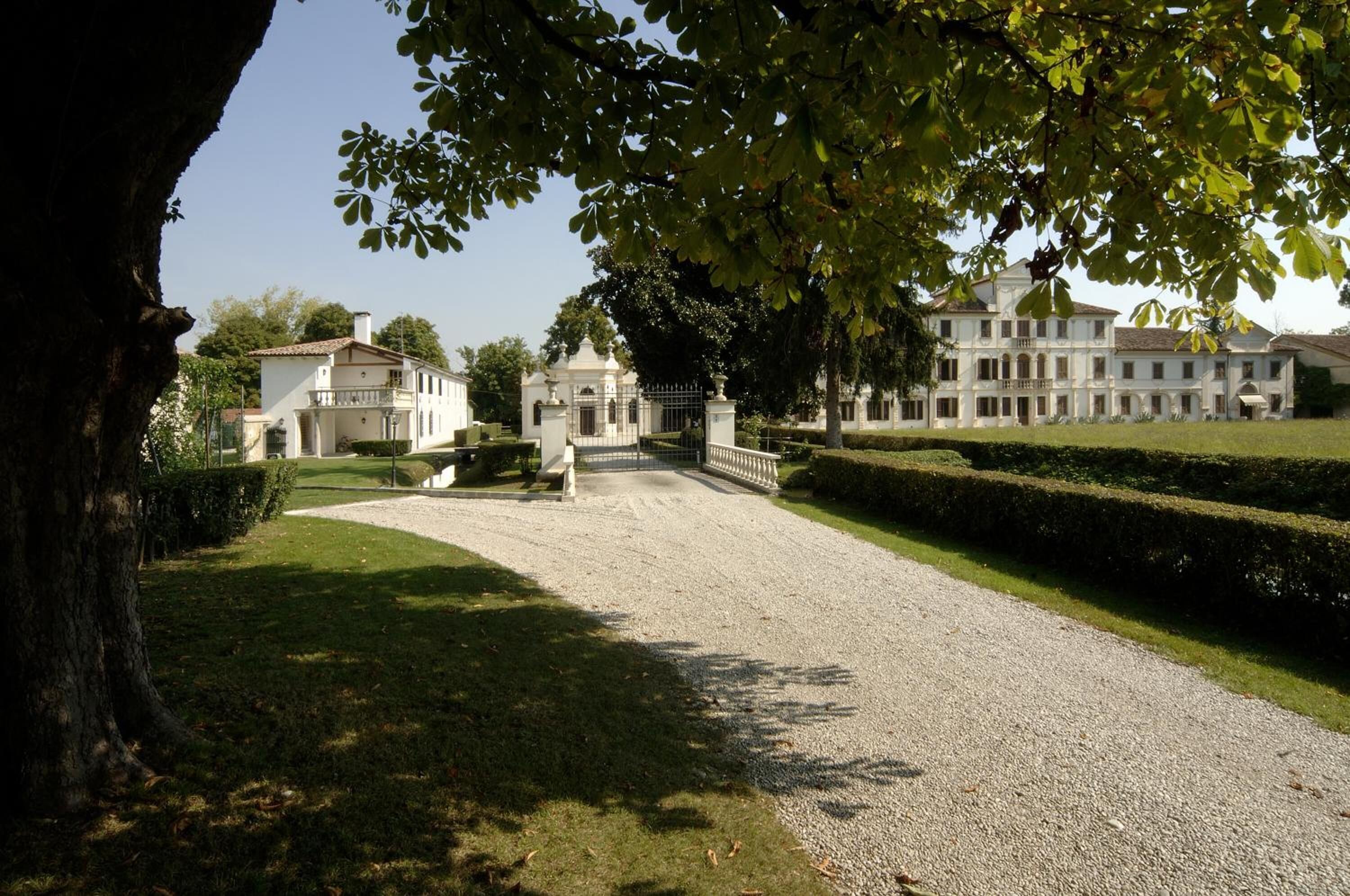 A large, white building with a formal entrance and well-maintained gardens.