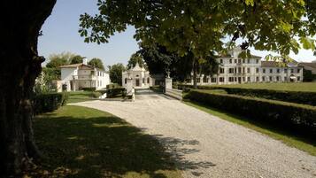 A large, white building with a formal entrance and well-maintained gardens.