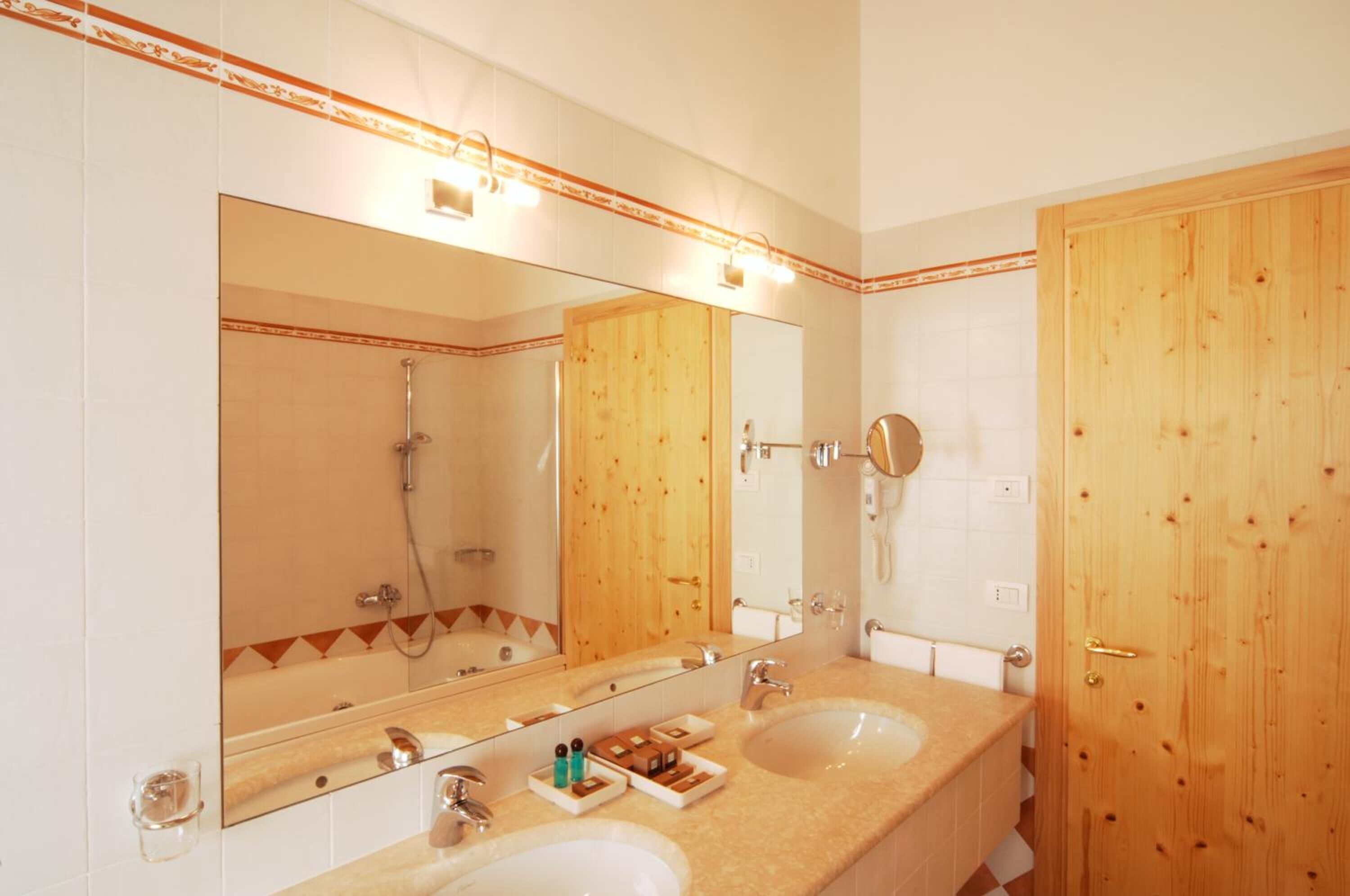 A bathroom with two sinks, a large mirror, and a wooden door.
