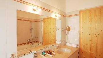 A bathroom with two sinks, a large mirror, and a wooden door.