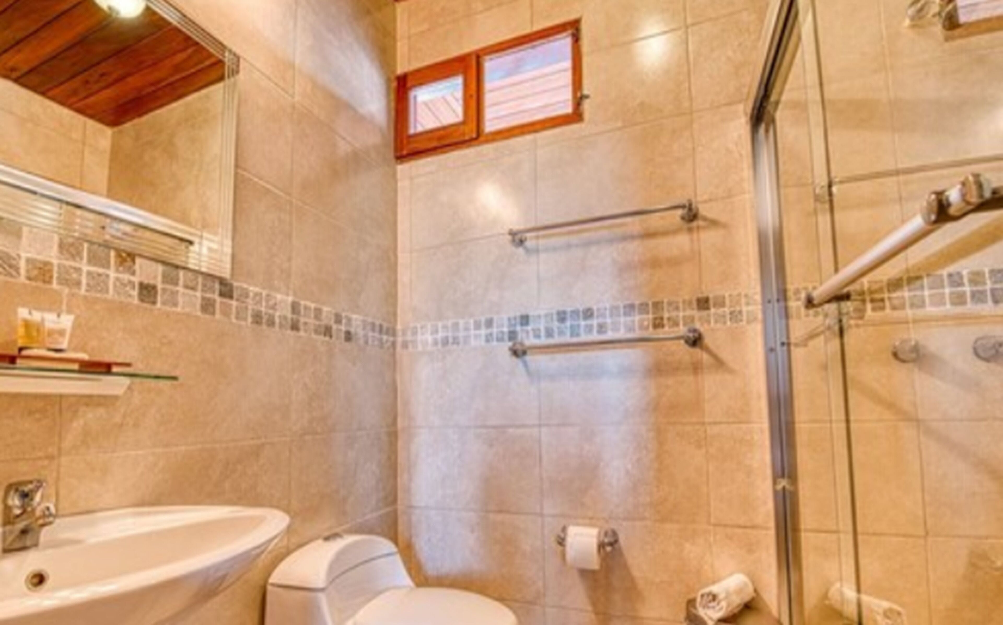 Un baño con ducha, inodoro y lavamanos.