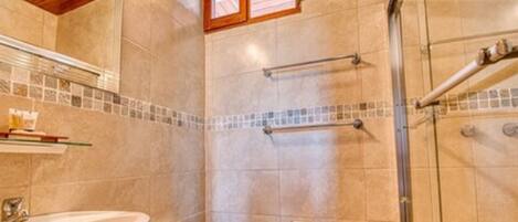 A bathroom with a shower, toilet, and sink.