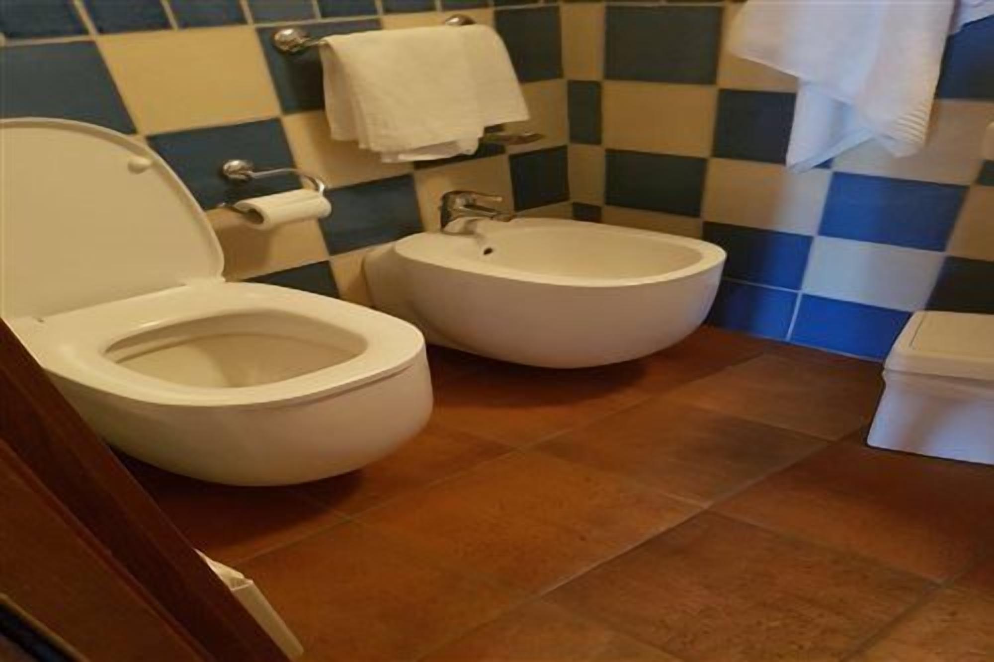 Une salle de bain avec deux toilettes, un porte-serviettes et un support à papier toilette.