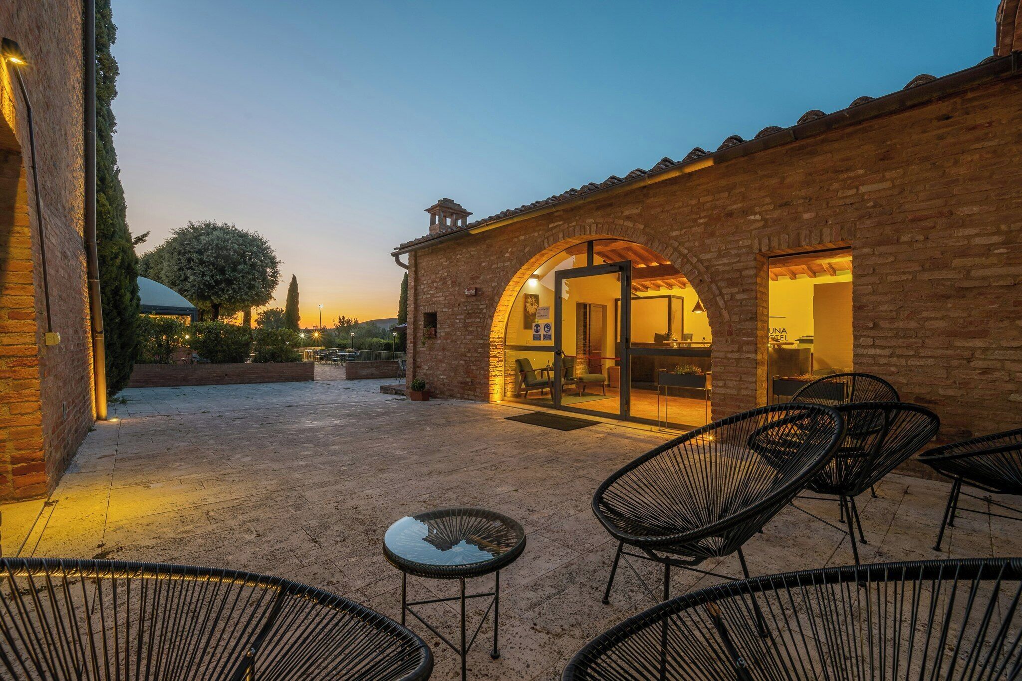 An outdoor seating area with brick walls and a clear sky.