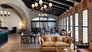 A spacious lobby with a high ceiling, a chandelier, a reception desk, and comfortable seating areas. - Parador de Ciudad Rodrigo (Ciudad Rodrigo)