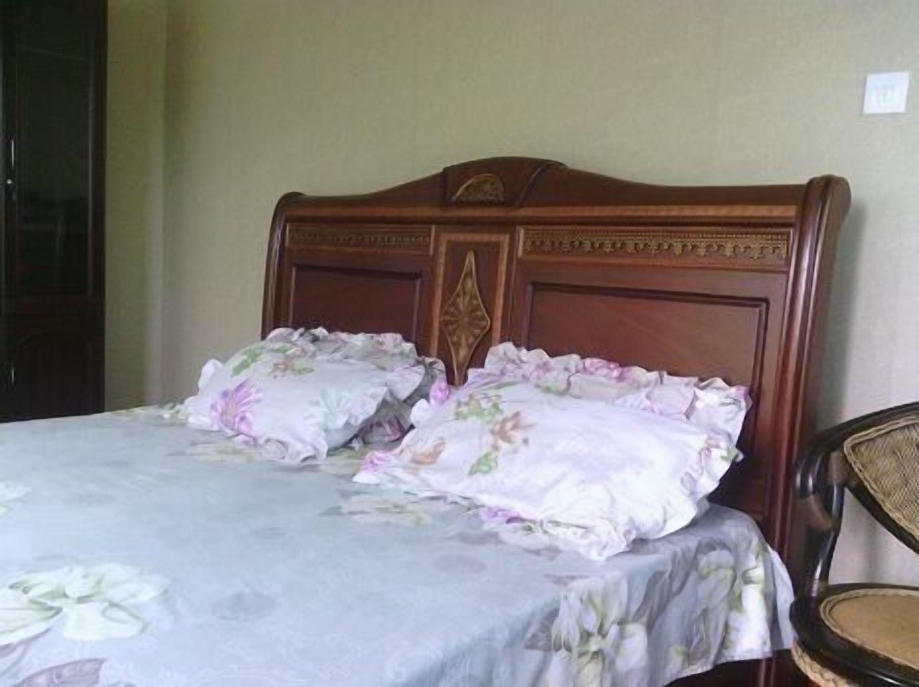 Una cama con ropa de cama floral y un cabecero de madera.