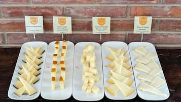 Four cheese platters with labels in front of a brick wall.