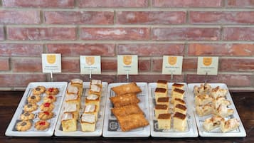 Una exhibición de diversos pasteles y postres en platos, cada uno identificado con su nombre.