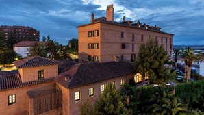 A multi-story building with a brick facade, multiple windows, and a flat roof. - Parador de Calahorra (Calahorra)