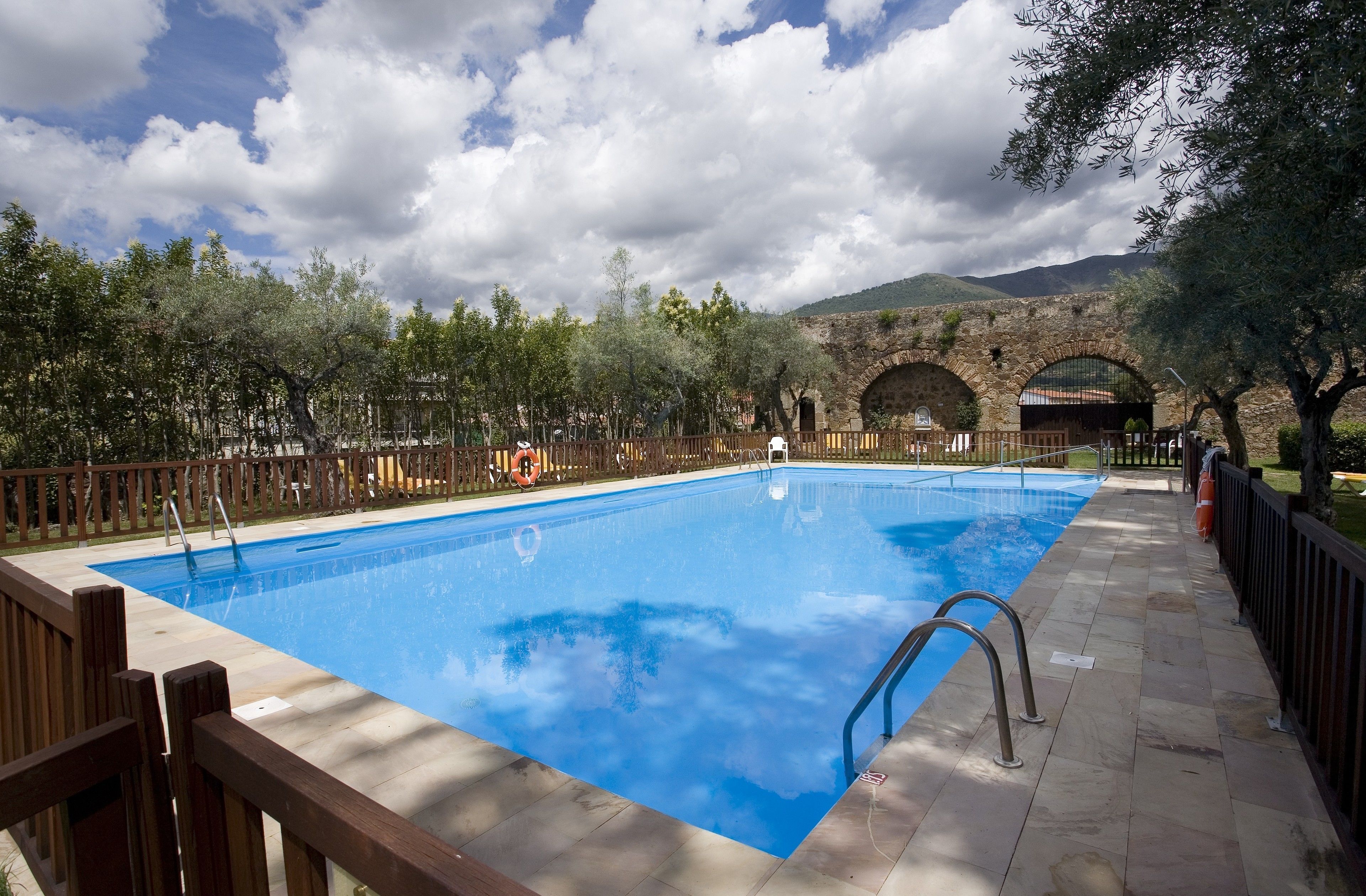 Una piscina al aire libre de temporada, sombrillas