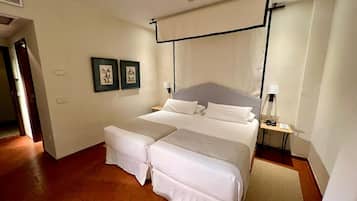 A double bed with a headboard, a bedside table with a lamp, and two framed pictures on the wall.