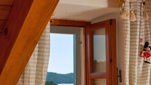 A room with a wooden window sill, a table with a lamp, and two apples. - Villa Vicina (Milna)