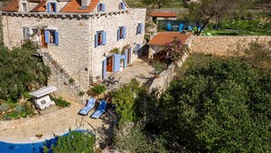 A stone villa with a swimming pool, outdoor seating, and a view of the surrounding landscape. - Villa Vicina (Milna)