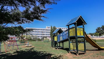 Children can play on the multi-level play structure with a slide in this well-maintained park area.