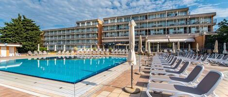 En säsongsöppen utomhuspool och parasoller