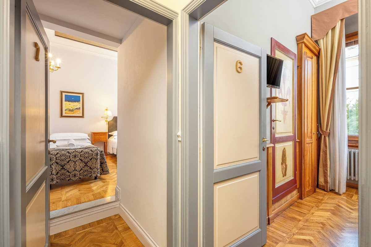 A hotel room with a bed, a nightstand, a lamp, and a painting on the wall.