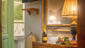 A wooden dresser with a bottle of wine, glasses, and flowers. - B&B Il Marzocco (Florence)