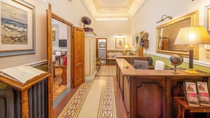 A room with a wooden desk, a globe, a lamp, and a large mirror. - B&B Il Marzocco (Florence)