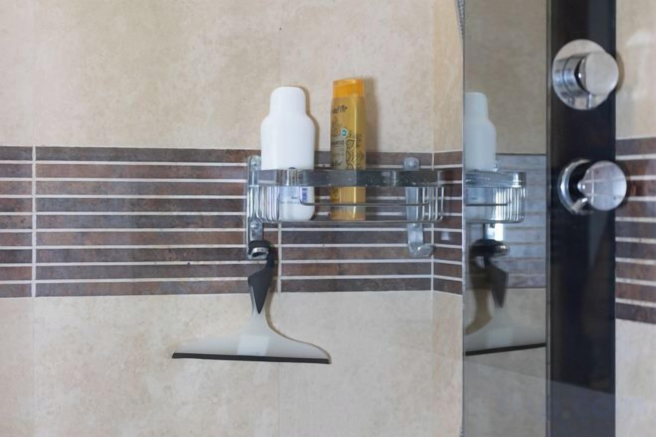 Une salle de bain équipée d’un miroir, d’un porte-serviettes et d’articles de toilette.