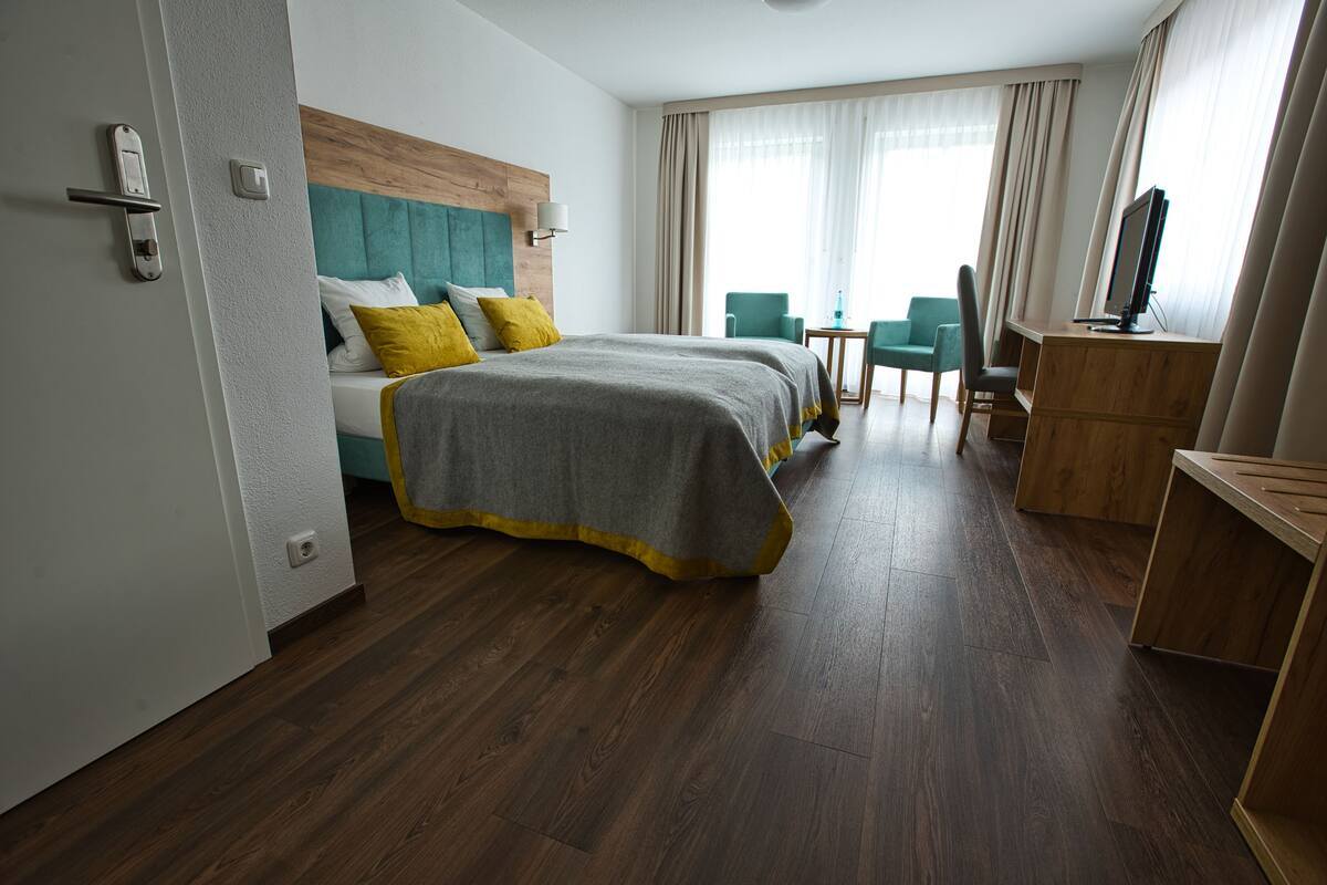 Ein Hotelzimmer mit einem großen Bett, einem Schreibtisch und einem Stuhl.