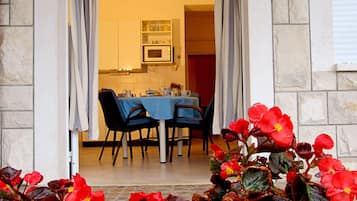 An open doorway leading to a dining area with a table set for two, chairs, and a kitchen visible in the background.