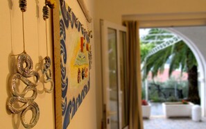 Un pasillo con un revestimiento decorativo que incluye una pintura colorida y un adorno colgante.