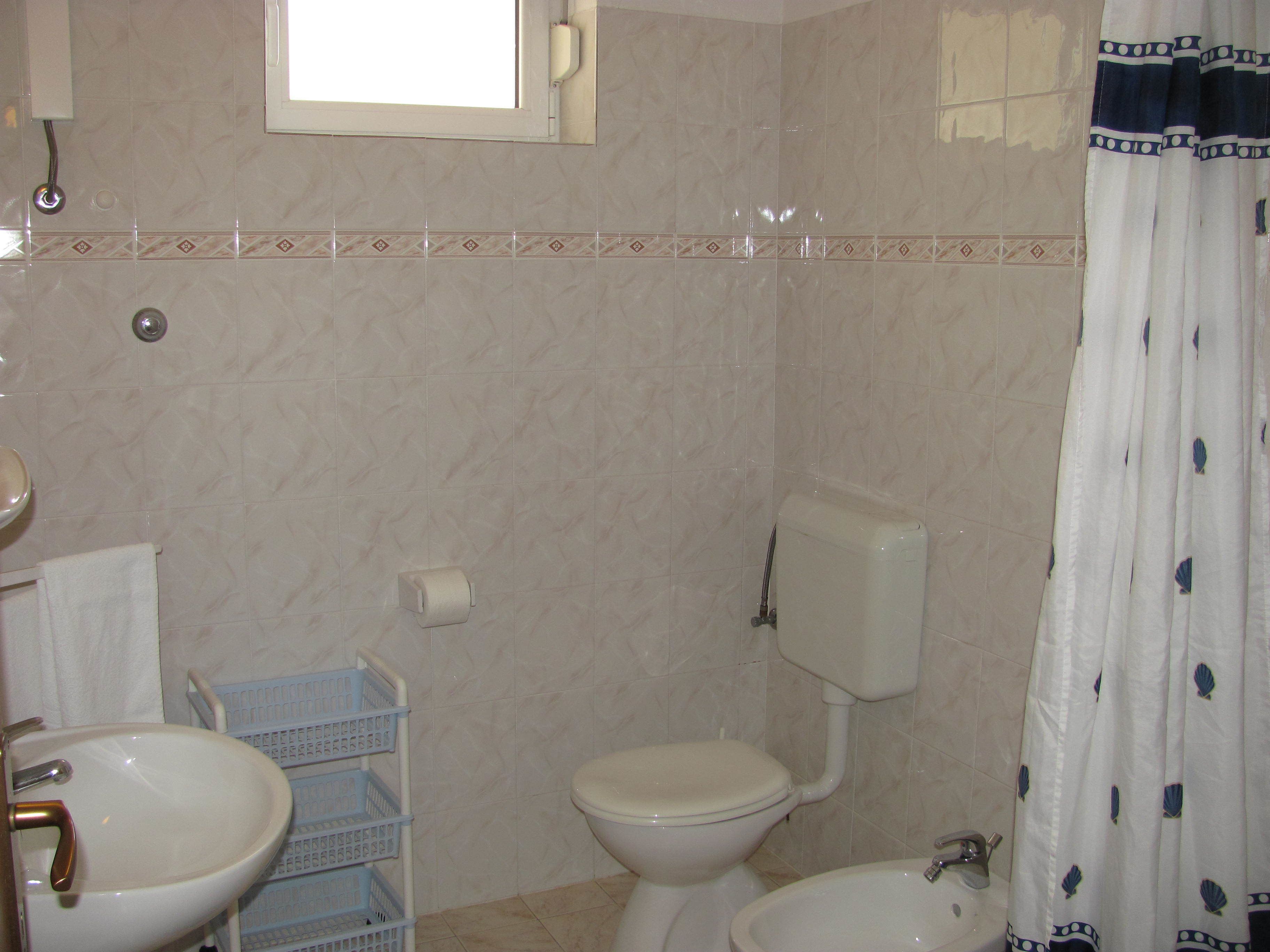 A bathroom with two sinks, a toilet, and a shower curtain.