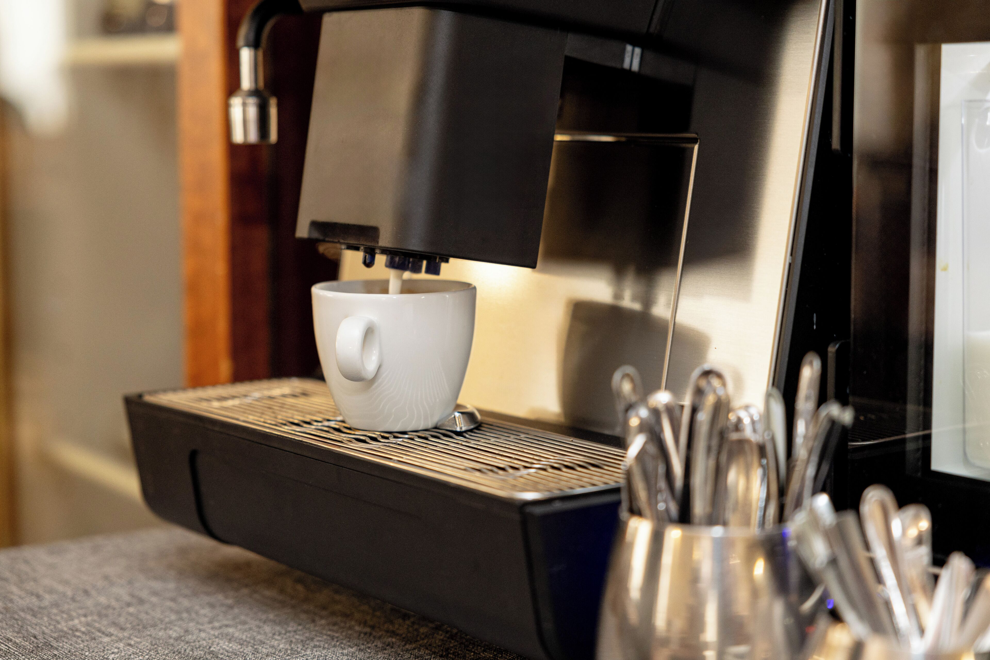Una cafetera con un portavasos y una cuchara.