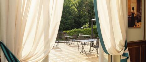 Una habitación con vista a un patio al aire libre, una mesa de comedor y sillas.
