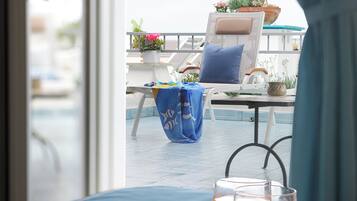 Ontbijtplateau met toast en sinaasappelsap op een balkon met uitzicht op het zwembad en plantenbakken.